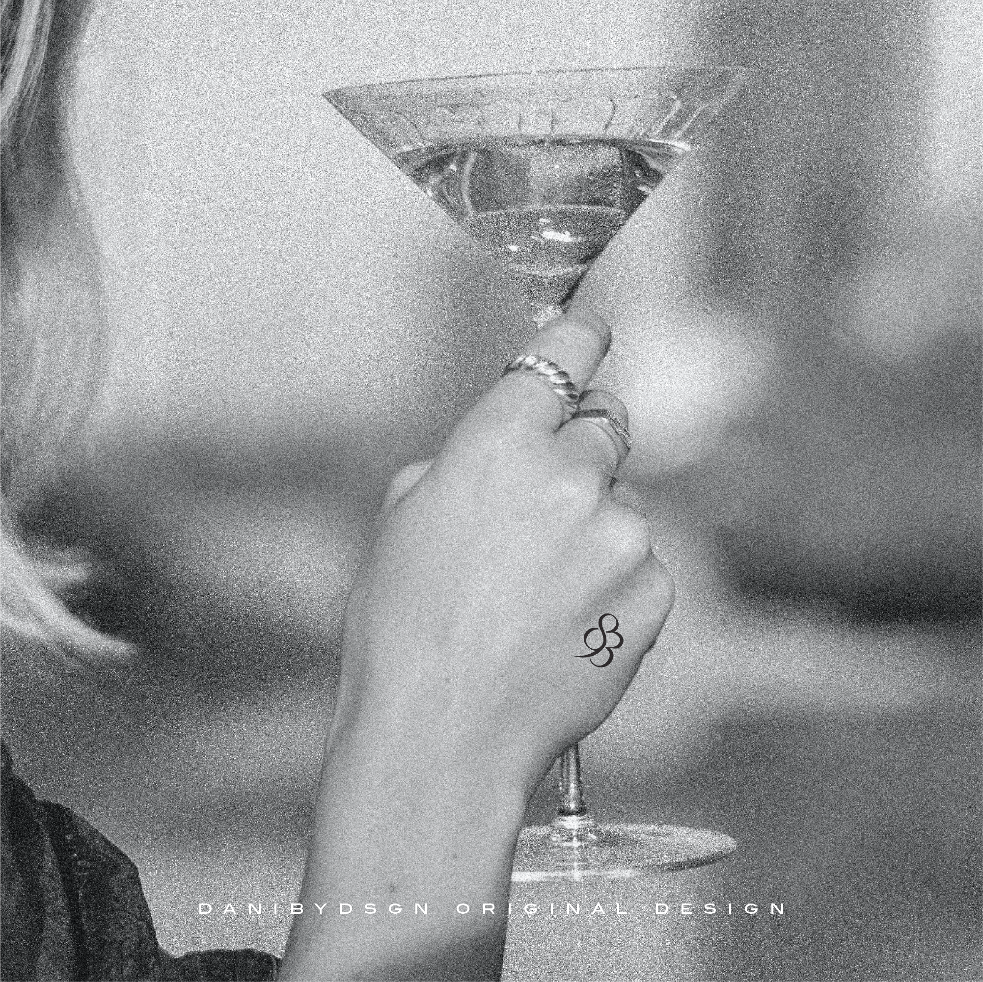 A chic '893' three Custom Initial Monograms tattoo design on a woman's wrist, as she holds a martini glass, design by Danibydsgn, showcases luxurious personal branding and custom logo design in the form of body art. This image reflects the high-end initial monogram custom logo designs suitable for special event marketing, wedding monograms, wall art and even clothing branding symbolizing an exclusive lifestyle or personal branding for body art.