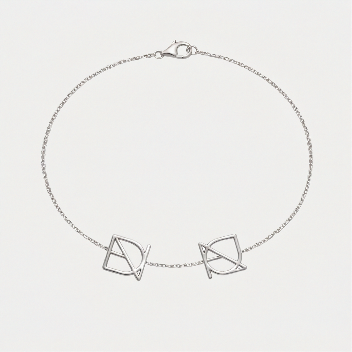 A delicate 9k white gold, Danibydsgn symbol cut out two symbol bracelet displayed on a clean, light off-white background.