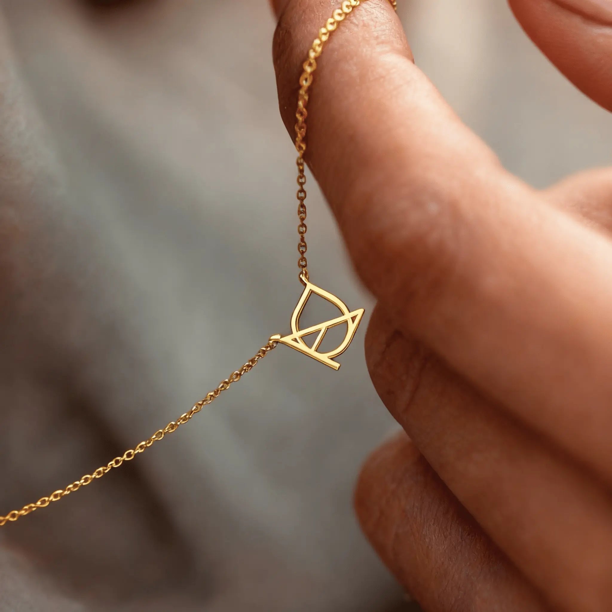 Custom gold symbol necklace held in hand – DaniByDsgn personalized luxury jewelry, 9k solid gold cut-out pendant, minimalist bespoke logo symbol necklace