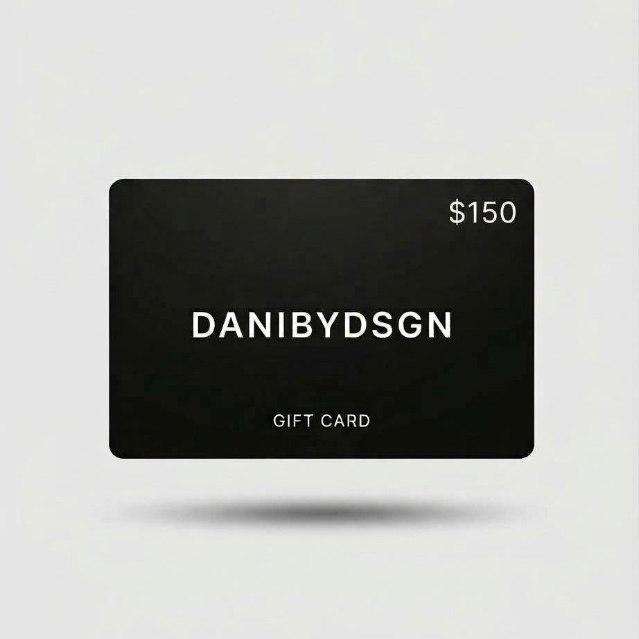 Close up of a Danibydsgn $150 black digital gift card with 'DANIBYDSGN' branding and $150 in the top right hand corner of the card. Card is set against a light background. Digital e-gift cards from Danibydsgn.