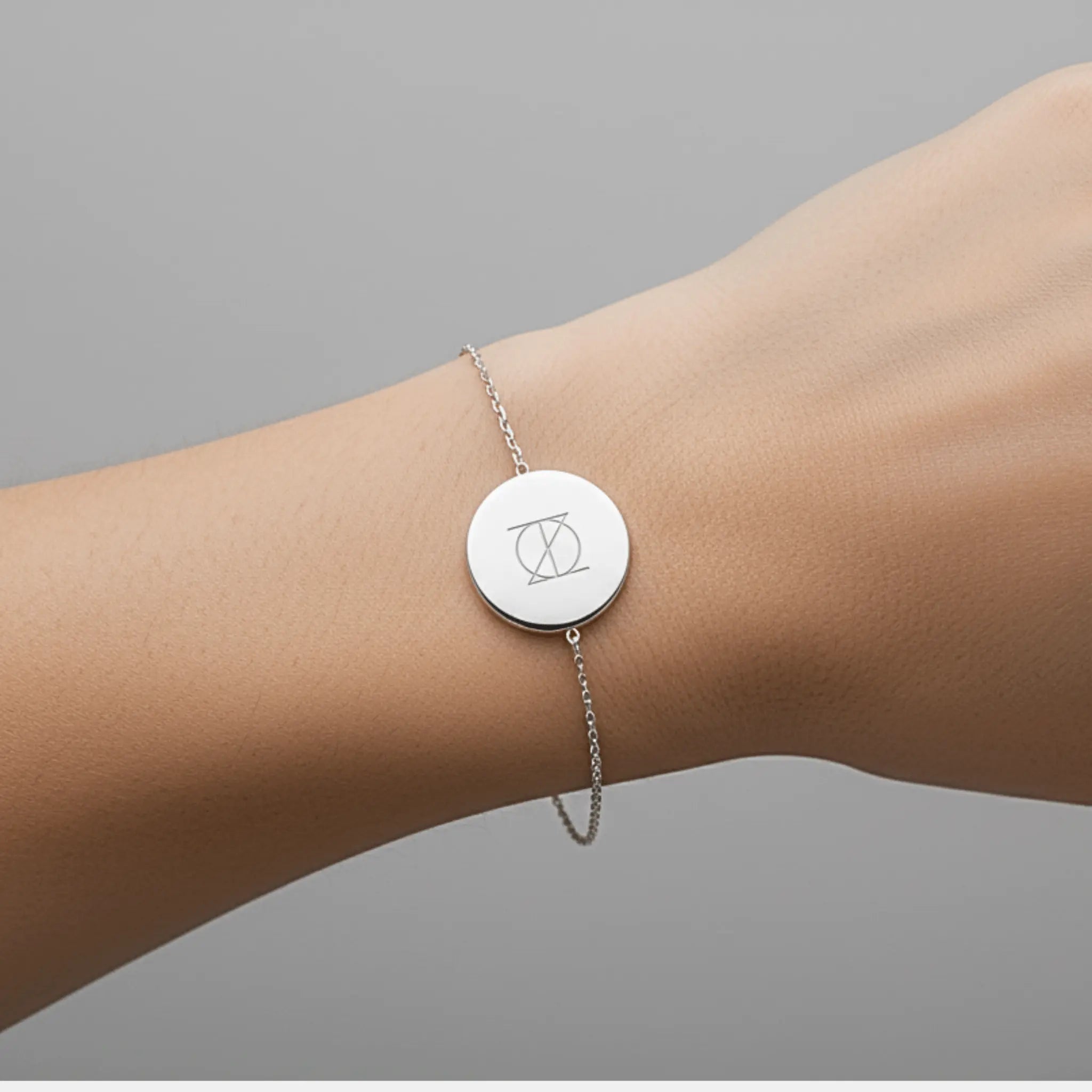 Engraved coin bracelet in 925 sterling silver featuring a custom symbol, designed by Danibydsgn for personalized jewelry.