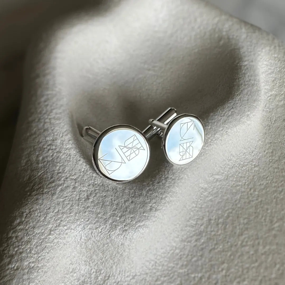 Engraved 925 sterling silver cufflinks by Danibydsgn showcasing a custom logo in soft lighting.