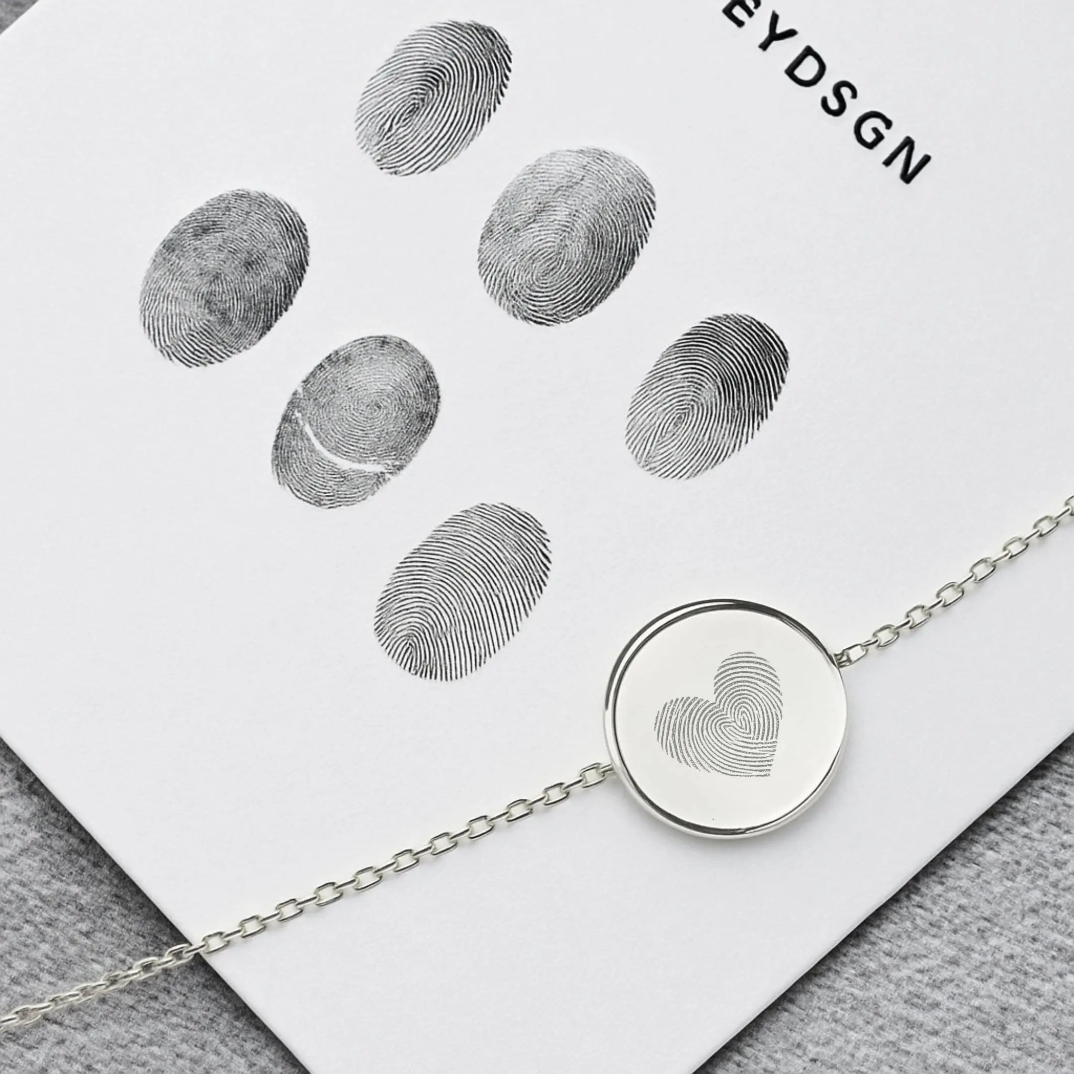 Heart fingerprint coin bracelet in 925 sterling silver by Danibydsgn, showcasing a personalized engraving detail.