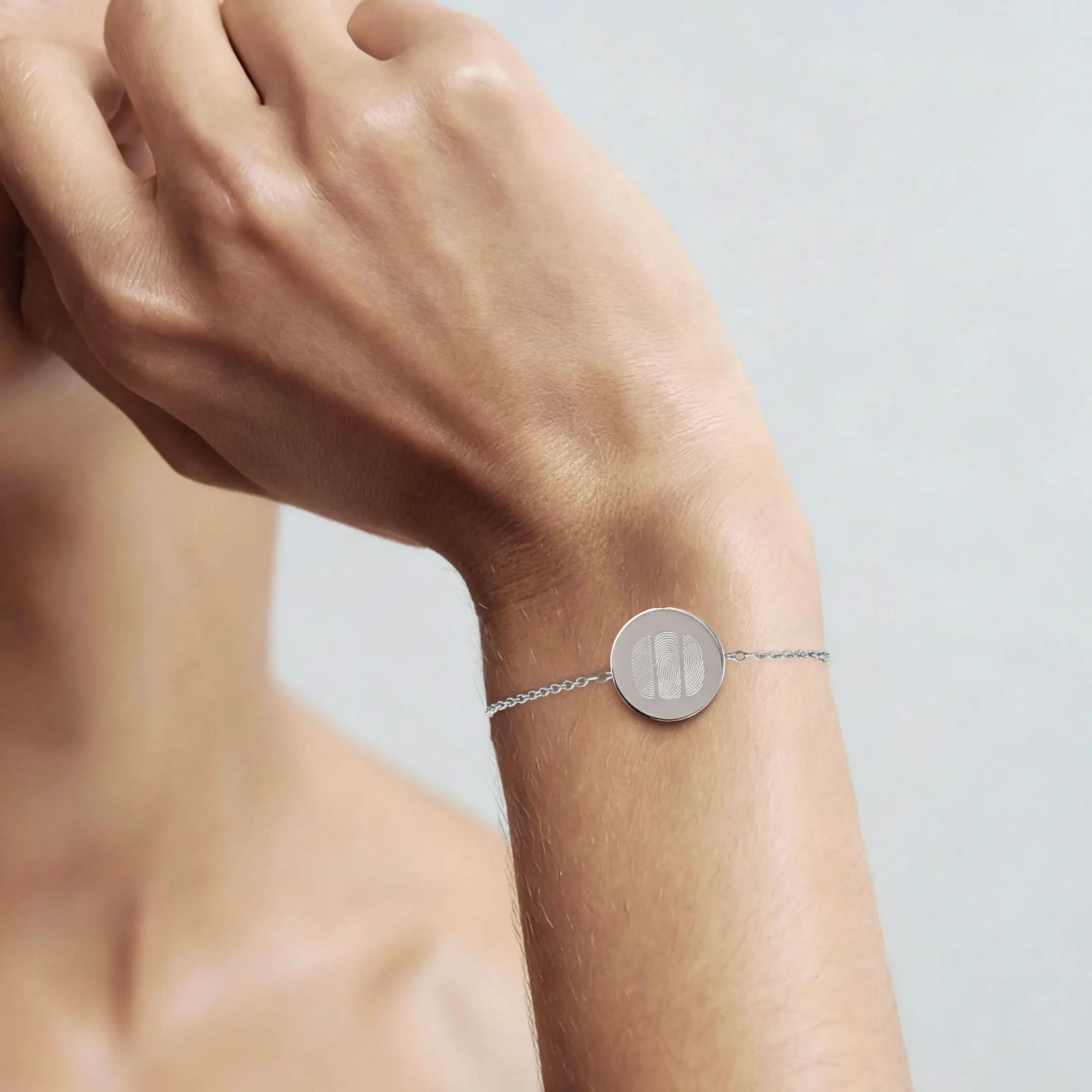 Three fingerprint coin bracelet in 925 sterling silver worn on a wrist, showcasing its elegant design by Danibydsgn.