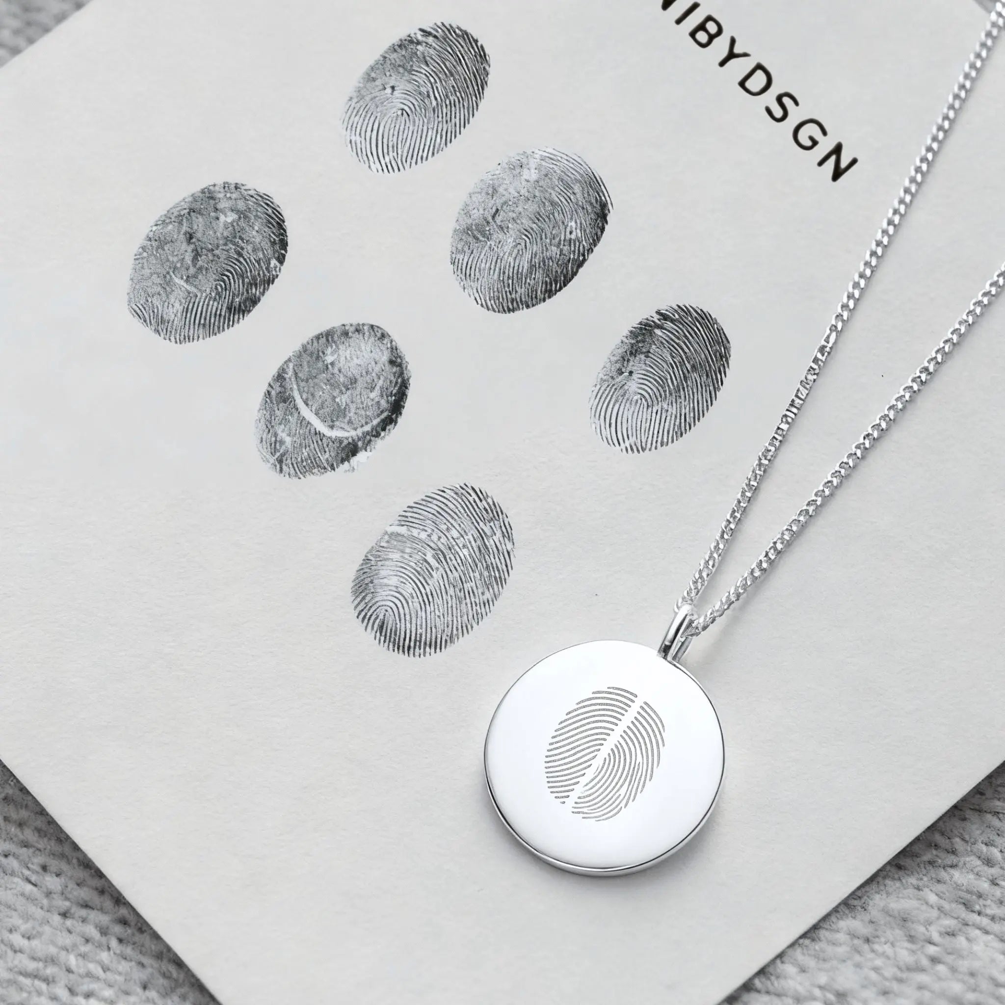 Two fingerprint coin necklace in 925 sterling silver by Danibydsgn, showcasing detailed fingerprint impressions.