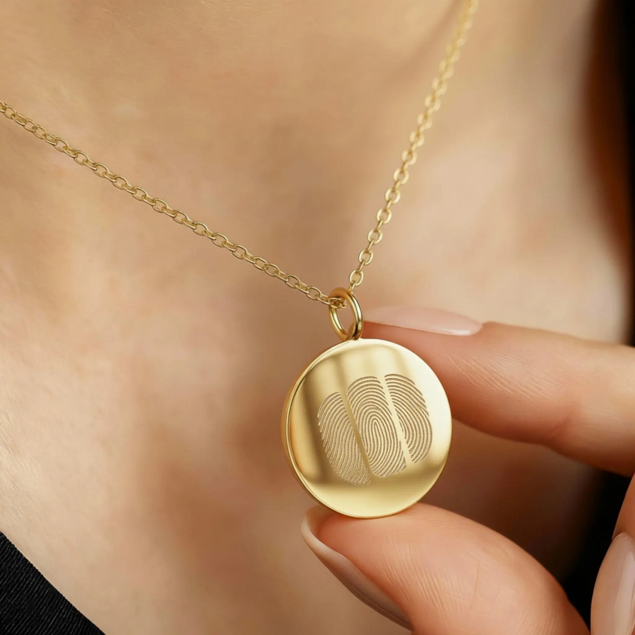 The Luxury Three Fingerprint Coin Necklace in 18K Gold Vermeil by Danibydsgn, shown worn close to the heart. The pendant features three finely engraved fingerprints symbolising love and connection, crafted from radiant gold vermeil for a timeless, heirloom-quality finish.