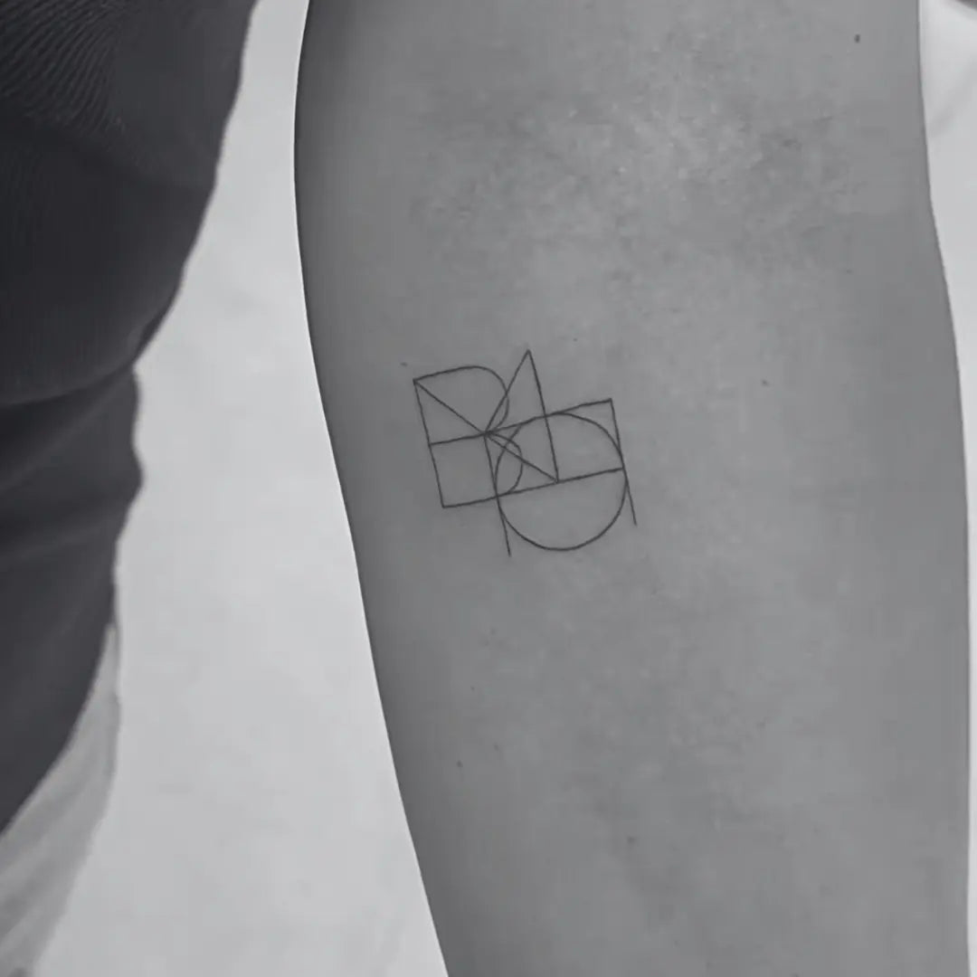 Joined monogram tattoo design by Danibydsgn featuring two geometric symbols in a fine line art style.