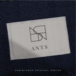 Detail of a clothing label showcasing the 'ANTS' logo with a sleek Danibydsgn business logo design. The simple yet elegant logo is an example of effective small business branding, crafted by a professional graphic designer. This tag illustrates the essence of business branding through its clean logo identity, suited for website brand logos and better end clothing branding such as Tshirts and Hoodies.