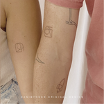 A couple showcase their matching fineline tattoo designs by Danibydsgn, commemorating their wedding anniversary date with a unique symbol that embodys their bond. These minimalist tattoos reflect a bespoke combination of personal branding and body art, serving as a timeless reminder of their special day. Danibydsgn is the original name logo creator with 30,000 personalized designs completed globally and over 1,700+ five star reviews.