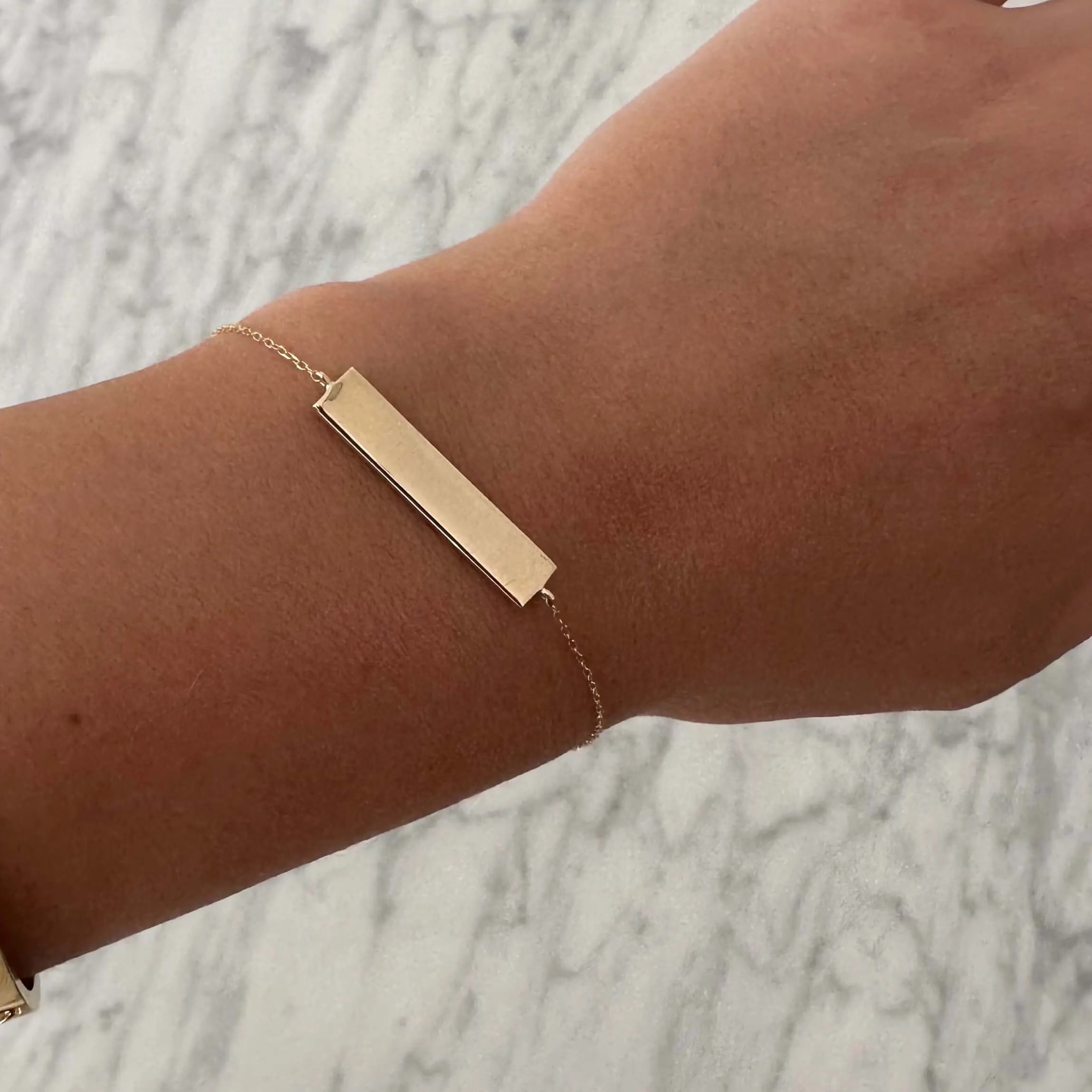 Engravable solid gold bar bracelet by Danibydsgn, showcasing a sleek design with a polished finish.