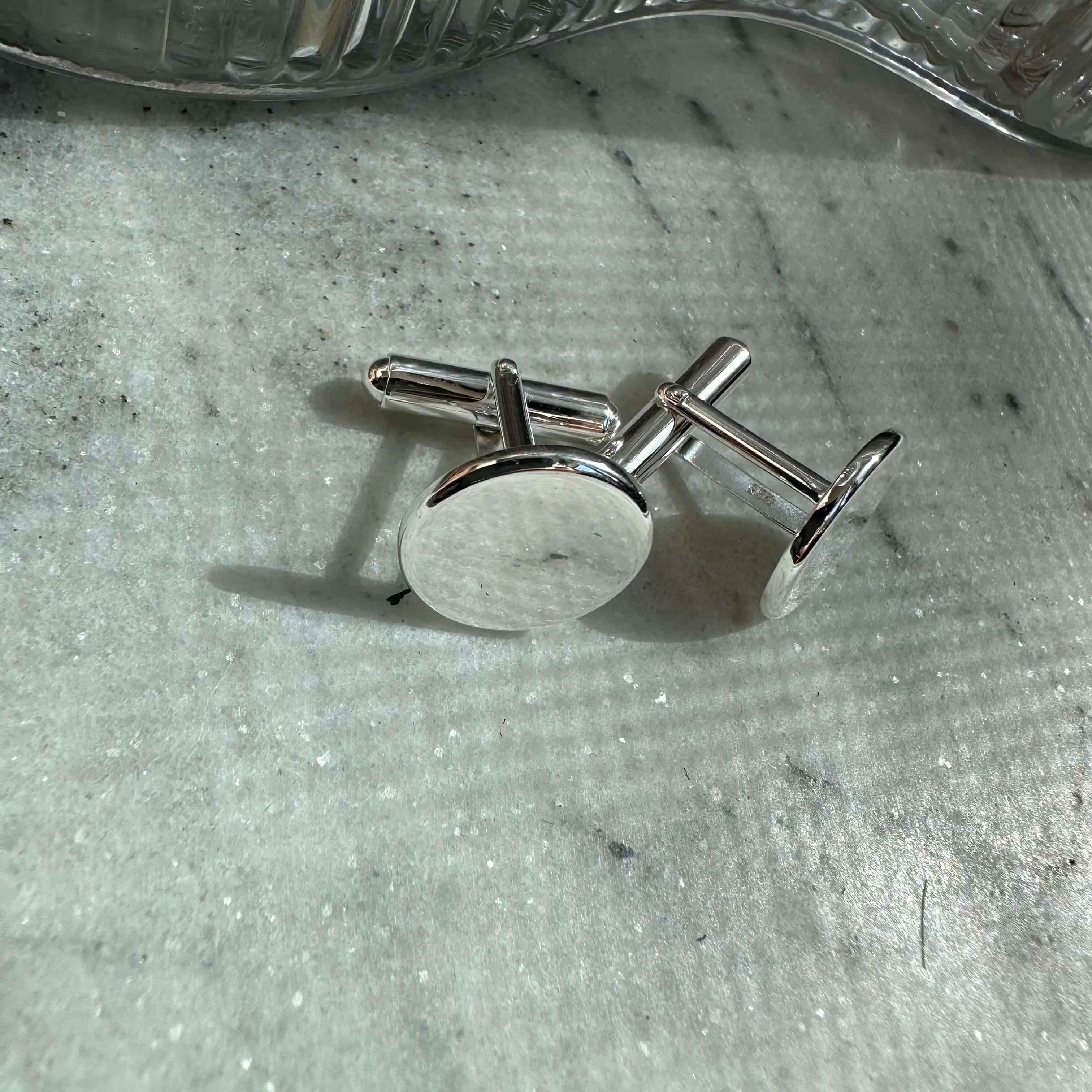 Engraved 925 sterling silver cufflinks by Danibydsgn, showcasing a sleek design and polished finish from an angled view.