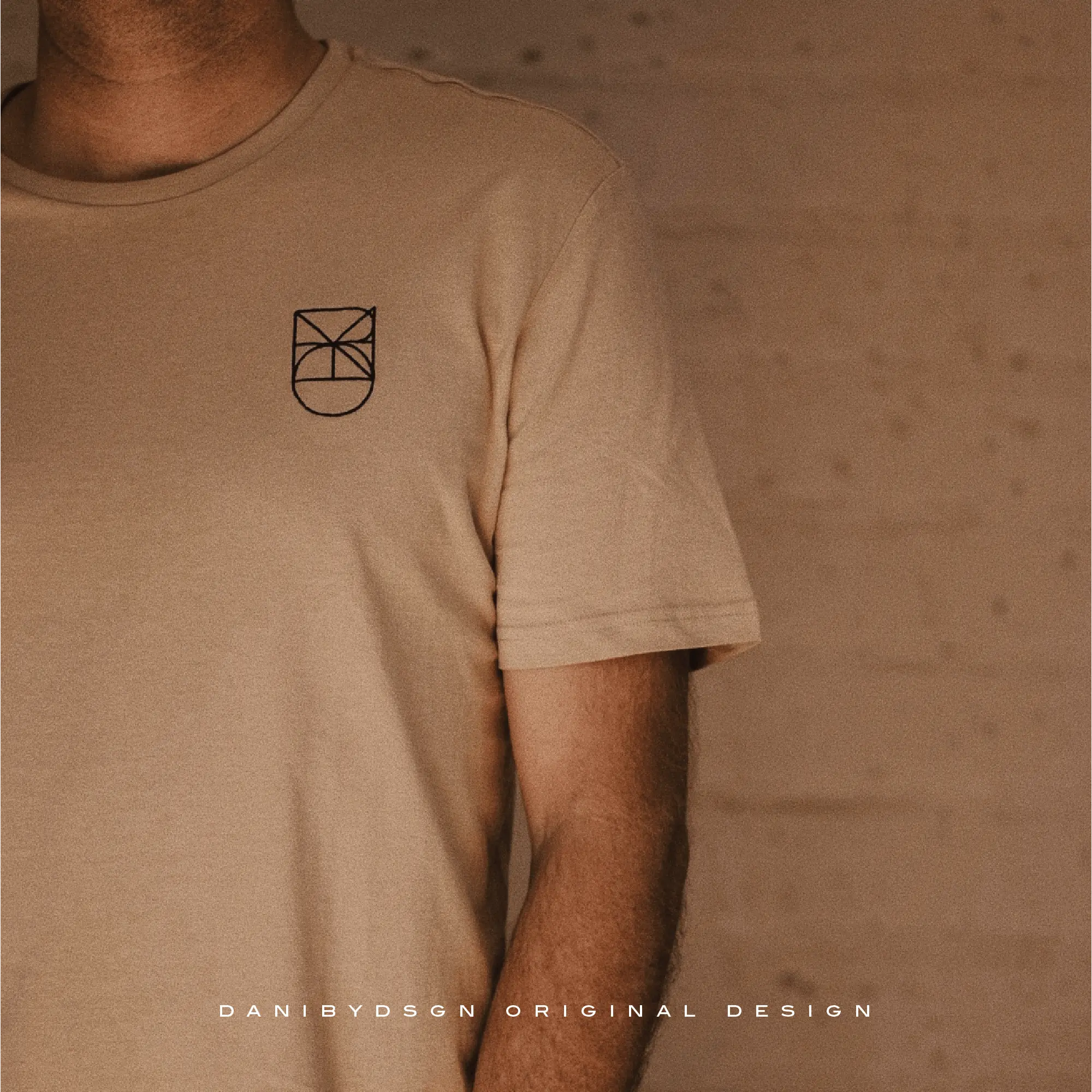 Beige minimal logo design on a t-shirt showcasing Danibydsgn's branding package for businesses.