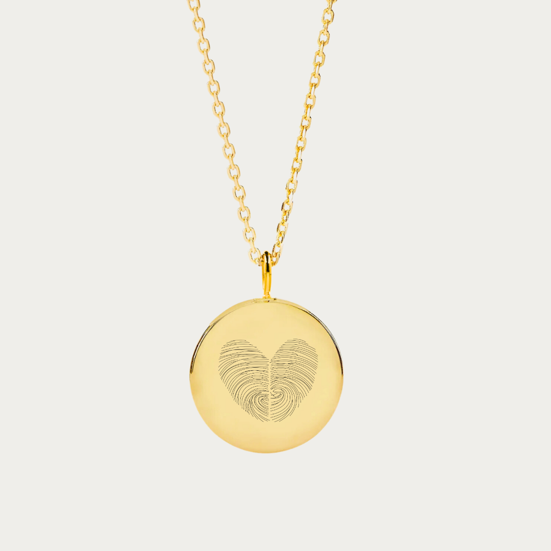 Elegant 18k gold vermeil coin pendant necklace from Danibydsgn, engraved with a unique heart fingerprint design with two overlapped fingerprints, making it an ideal romantic gift and a precious fingerprint keepsake. This custom necklace marries the timeless appeal of a fingerprint pendant necklace with the personal touch of a fingerprint heart pendant, creating a truly bespoke piece of jewelry.  It’s the perfect piece to add to your custom jewelry collection or give as a beautiful meaningful gift