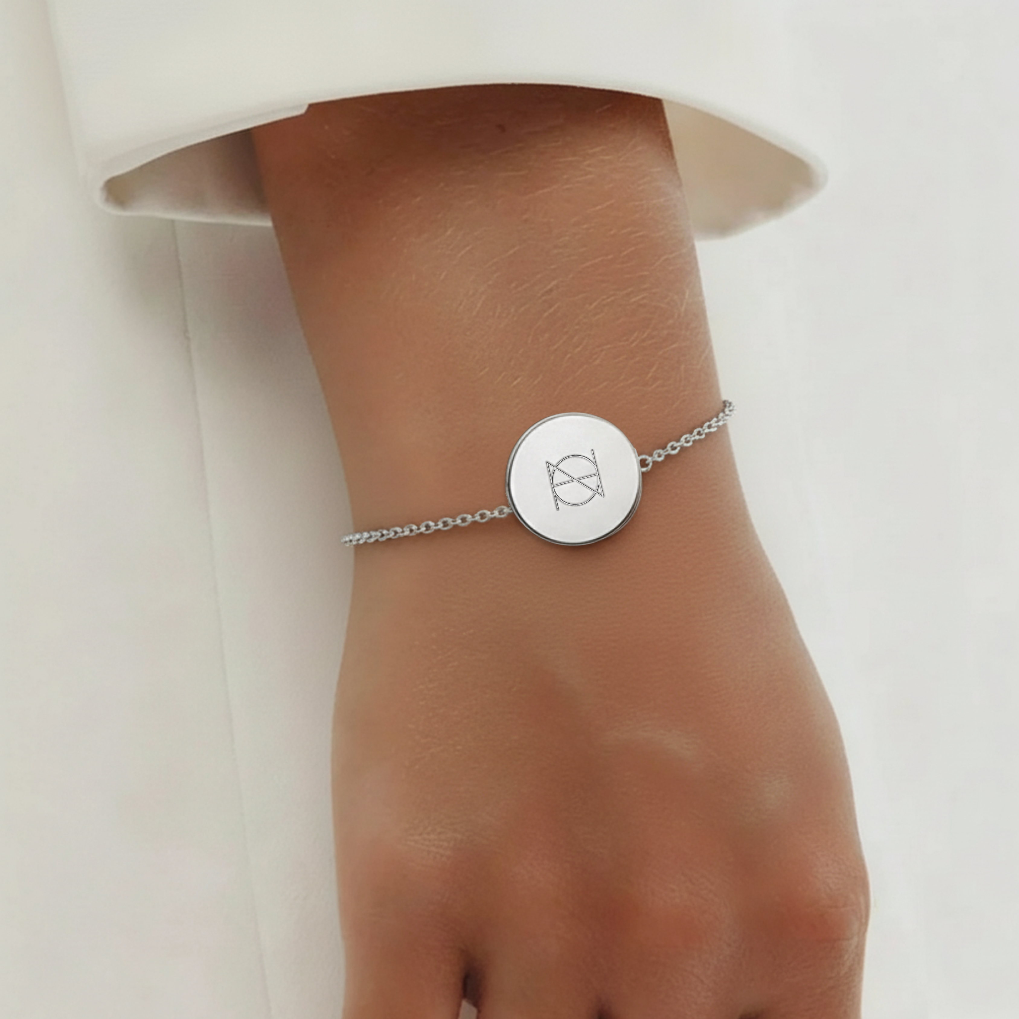 925 Sterling Silver bracelet with a circular pendant featuring a custom Danibydsgn single symbol design and bracelet is on a lady's wrist.