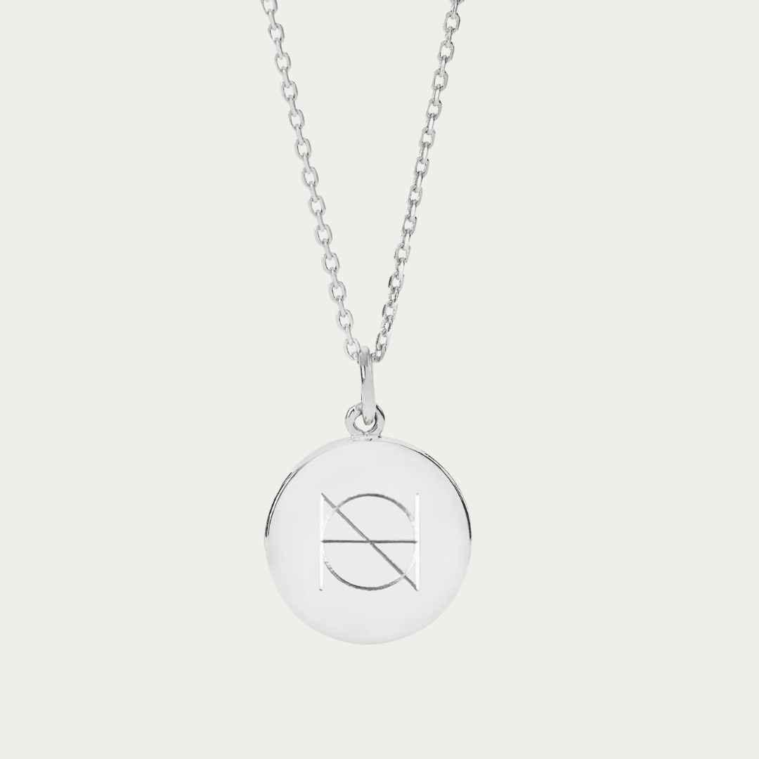Created from high-quality 925 sterling silver, this pendant necklace elegantly showcases a Danibydsgn custom name logo, intricately engraved inhouse for a personal touch. Not just a keepsake necklace, it transcends into everyday luxury. Also available as a custom engraved necklace in 9ct gold and 18k gold vermeil, it's an ideal choice for those seeking a meaningful piece of jewelry that captures their personal story or as a refined memorial necklace.  This pic shows an engraved pendant on a silver chain.