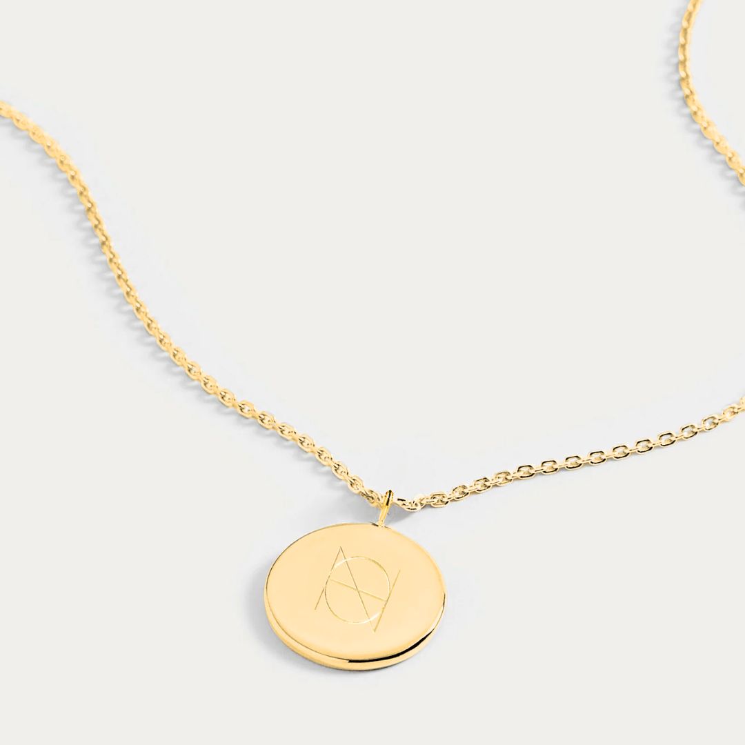 Our Engravable Gold Coin Necklace merges luxury and elegance with personalized charm. The perfect canvas for a Danibydsgn custom logo design to be engraved onto it.  This stunning necklace epitomizes the 18k gold vermeil luxury. It's not just a coin necklace; it’s a token of personal expression, a keepsake memorial jewelry item that can be personalized with a name or meaningful date, making it a quintessential gold necklace choice as a heartfelt personalized gift or to commemorate a special occasion.