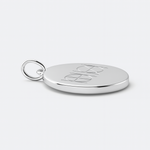A 925 Sterling Silver coin necklace with an engraved custom Danibydsgn logo design on it, of two symbol on a light coloured background.