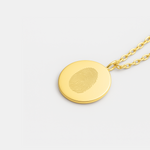 18k Gold Vermeil luxury coin pendant necklace with a single fingerprints engraved on the pendant and the photo is of the pendant on a chain on a light coloured background