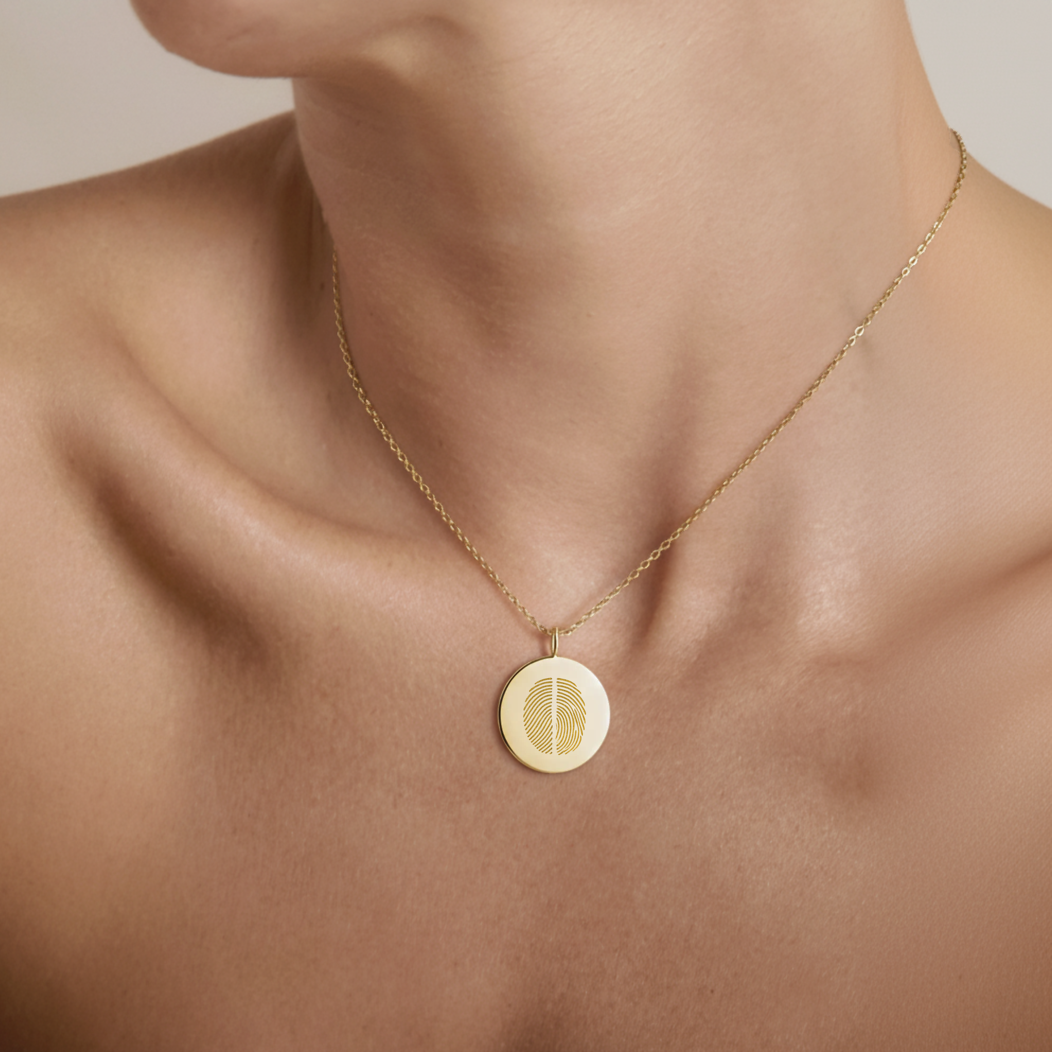 18k Gold Vermeil luxury coin pendant necklace with 2 fingerprints engraved on the pendant and pendant is around the neck of a lady.
