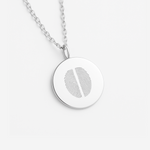 925 sterling silver  luxury coin pendant necklace with 2 fingerprints engraved on the pendant and pendant is on a chain on a light coloured background