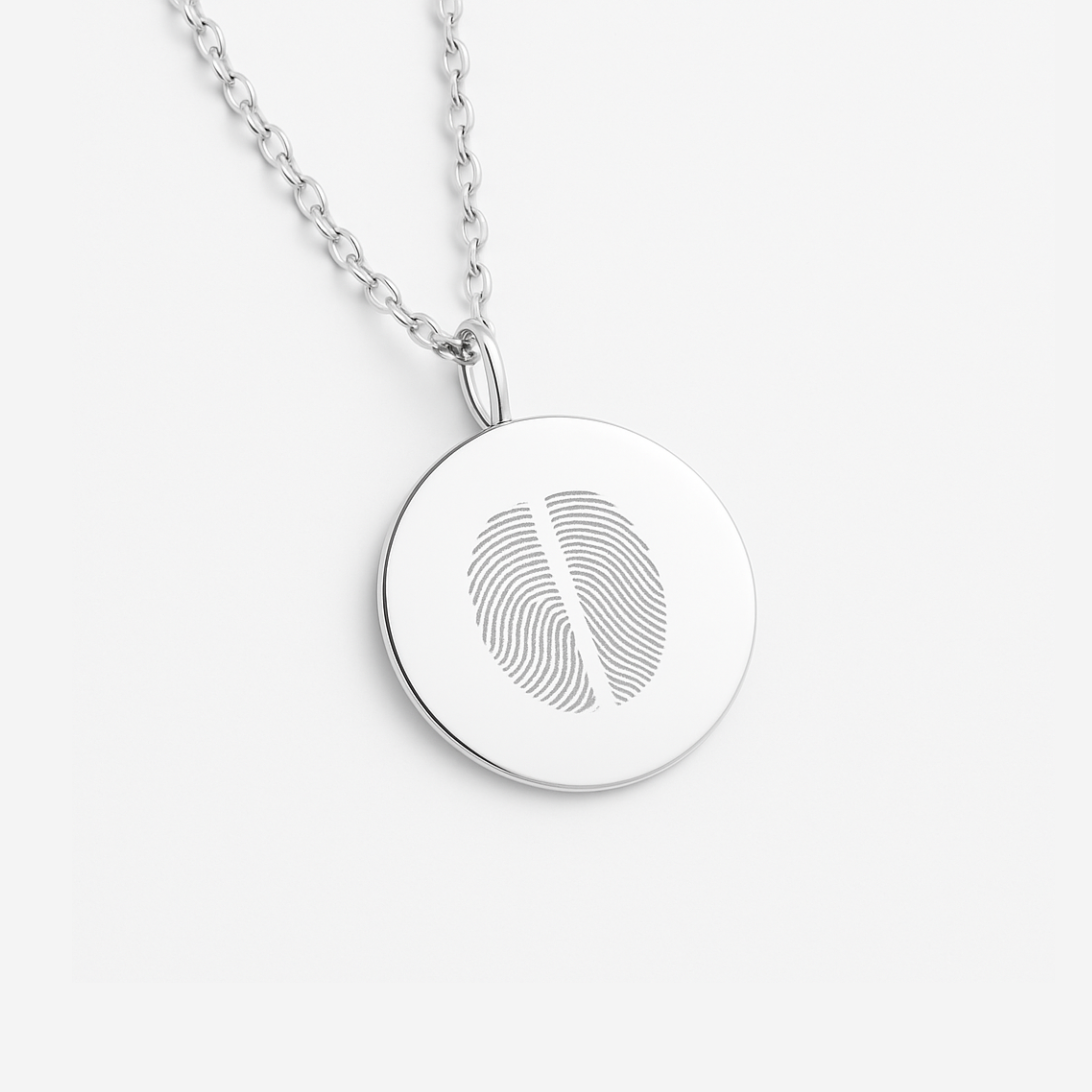 925 sterling silver  luxury coin pendant necklace with 2 fingerprints engraved on the pendant and pendant is on a chain on a light coloured background