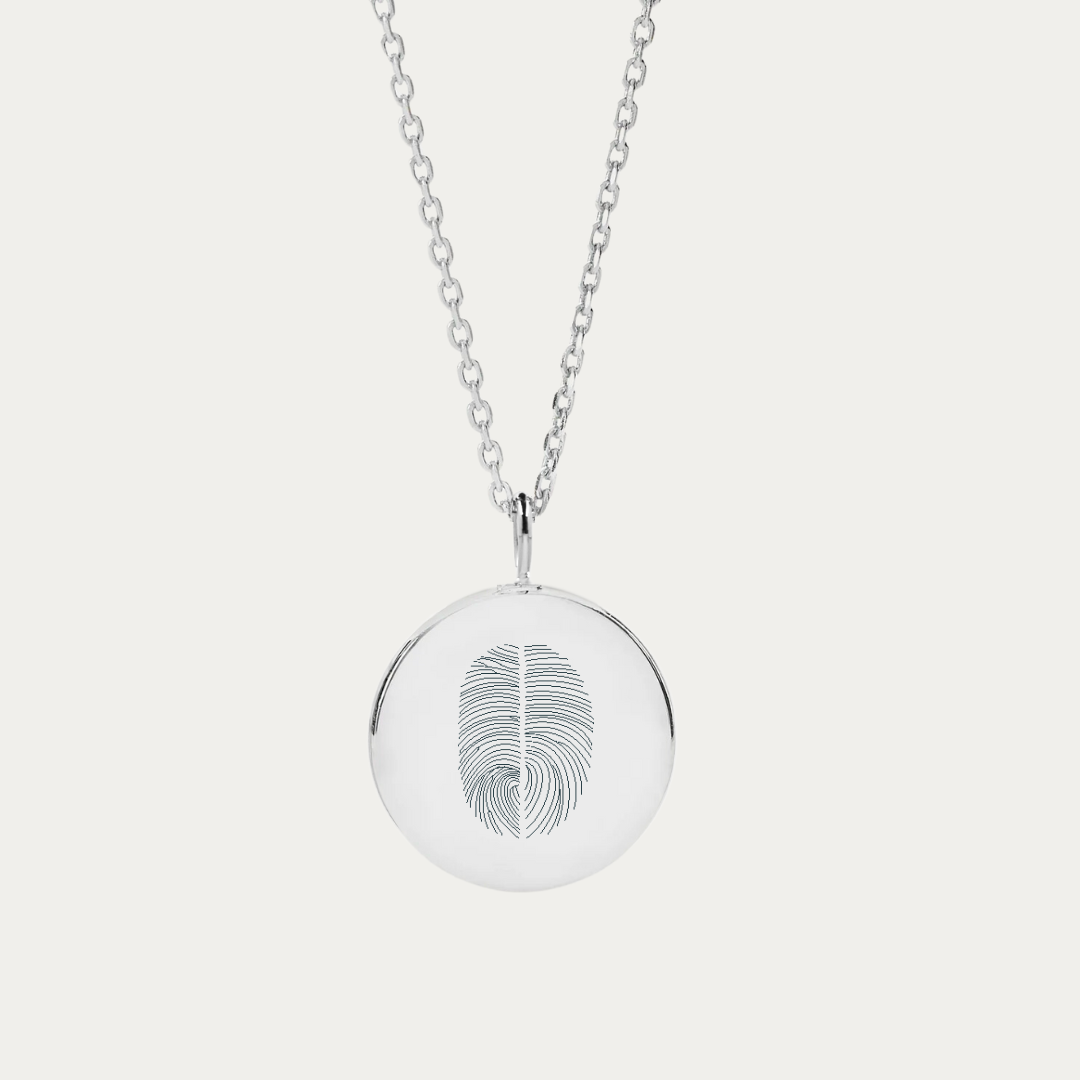 The Duo Fingerprint Silver Coin Necklace captures a unique bond with a sterling silver pendant featuring two fingerprints. It's not just a piece of engraved jewelry; it's a fingerprint keepsake, a memorial gift that holds a story. With the option to add a thumb print, this coin pendant necklace transforms into a bespoke keepsake gift, embodying both elegance and meaning. Engravable on both sites this luxury sterling silver necklace makes the perfect personalized meaningful gift. 