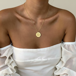 18k Gold Vermeil luxury coin pendant necklace with 3 fingerprints engraved on the pendant and pendant is on a chain around a lady's neck.