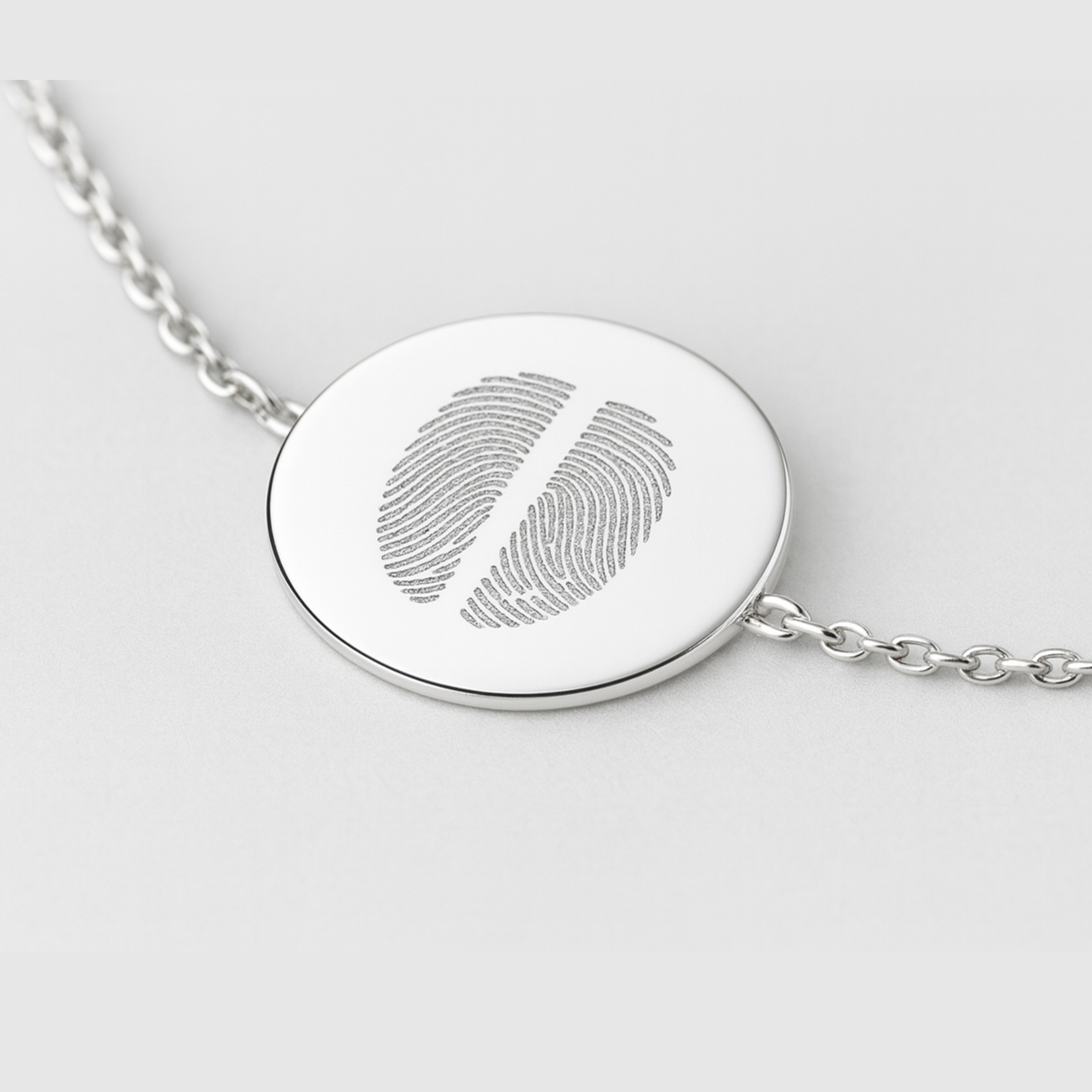925 Sterling Silver bracelet with a circular coin pendant design engraved with two fingerprints, on a light background.