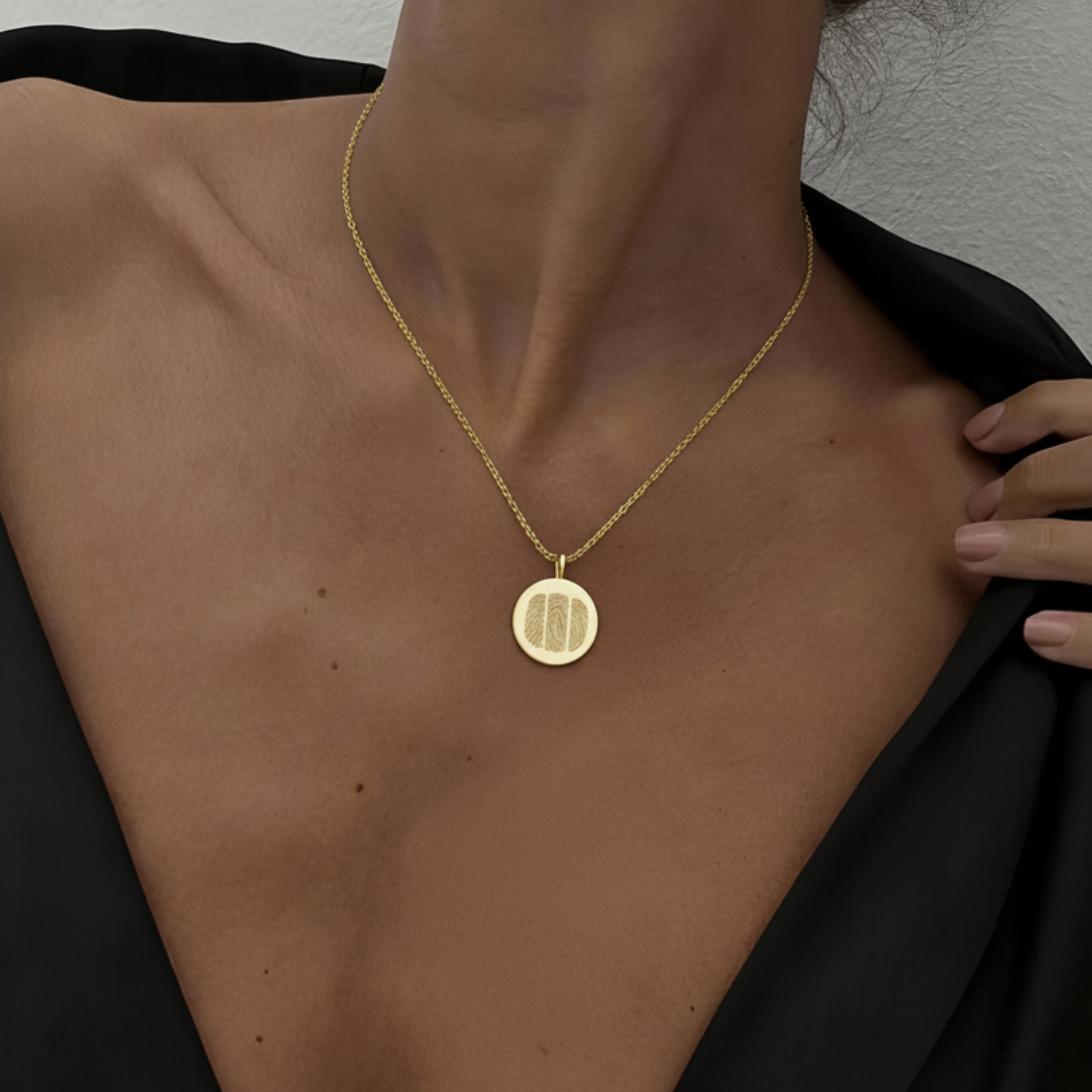 18k Gold Vermeil luxury coin pendant necklace with 3 fingerprints engraved on the pendant and pendant is on a chain around a lady's neck.