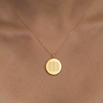 18k Gold Vermeil luxury coin pendant necklace with 3 fingerprints engraved on the pendant and pendant is on a chain and sitting around a ladies neck in a close up photo.