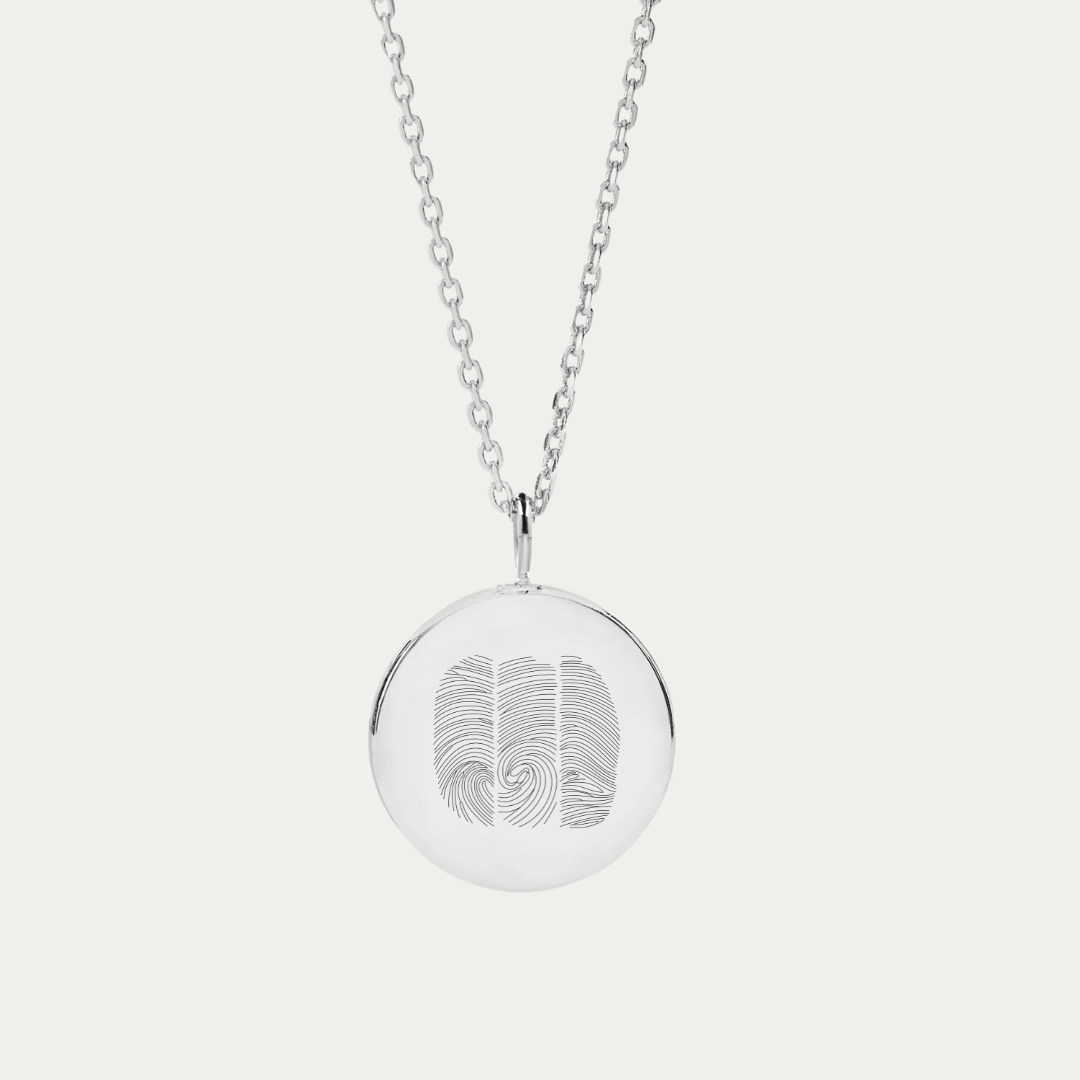 This sterling silver necklace features a coin pendant with a trio of fingerprints. This sterling silver necklace with a three fingerprint design is perfect as a personalized gift or as memorial jewelry.  A versatile piece, it serves both as a thumb print pendant and a cherished fingerprint keepsake. The necklace's adjustable chain adds a layer of practical elegance, making it an ideal selection for memorial jewelry or a keepsake gift that signifies something truly special.