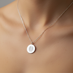 925 sterling silver luxury coin pendant necklace with 2 fingerprints engraved on the pendant and pendant is around the neck of a lady.