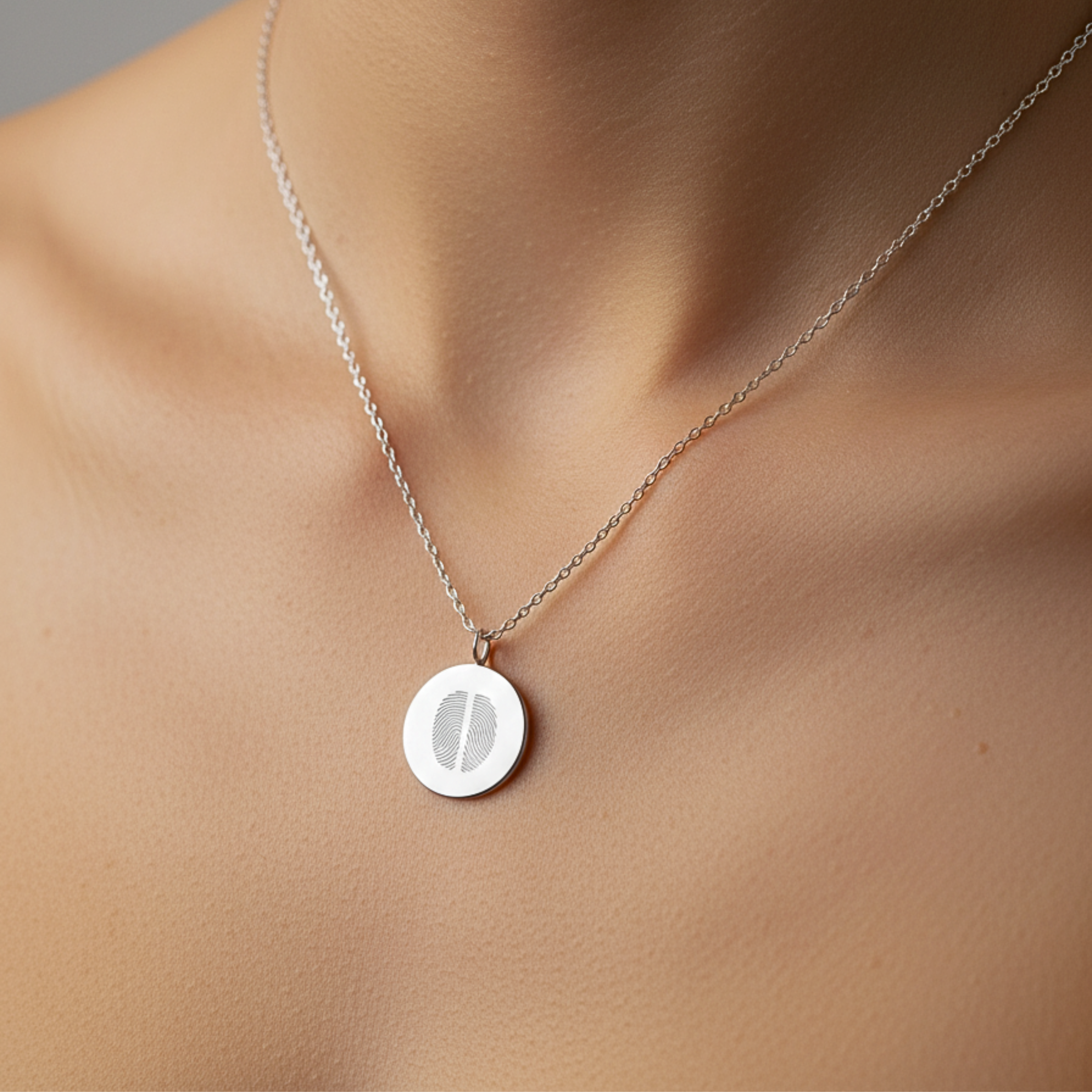 925 sterling silver luxury coin pendant necklace with 2 fingerprints engraved on the pendant and pendant is around the neck of a lady.