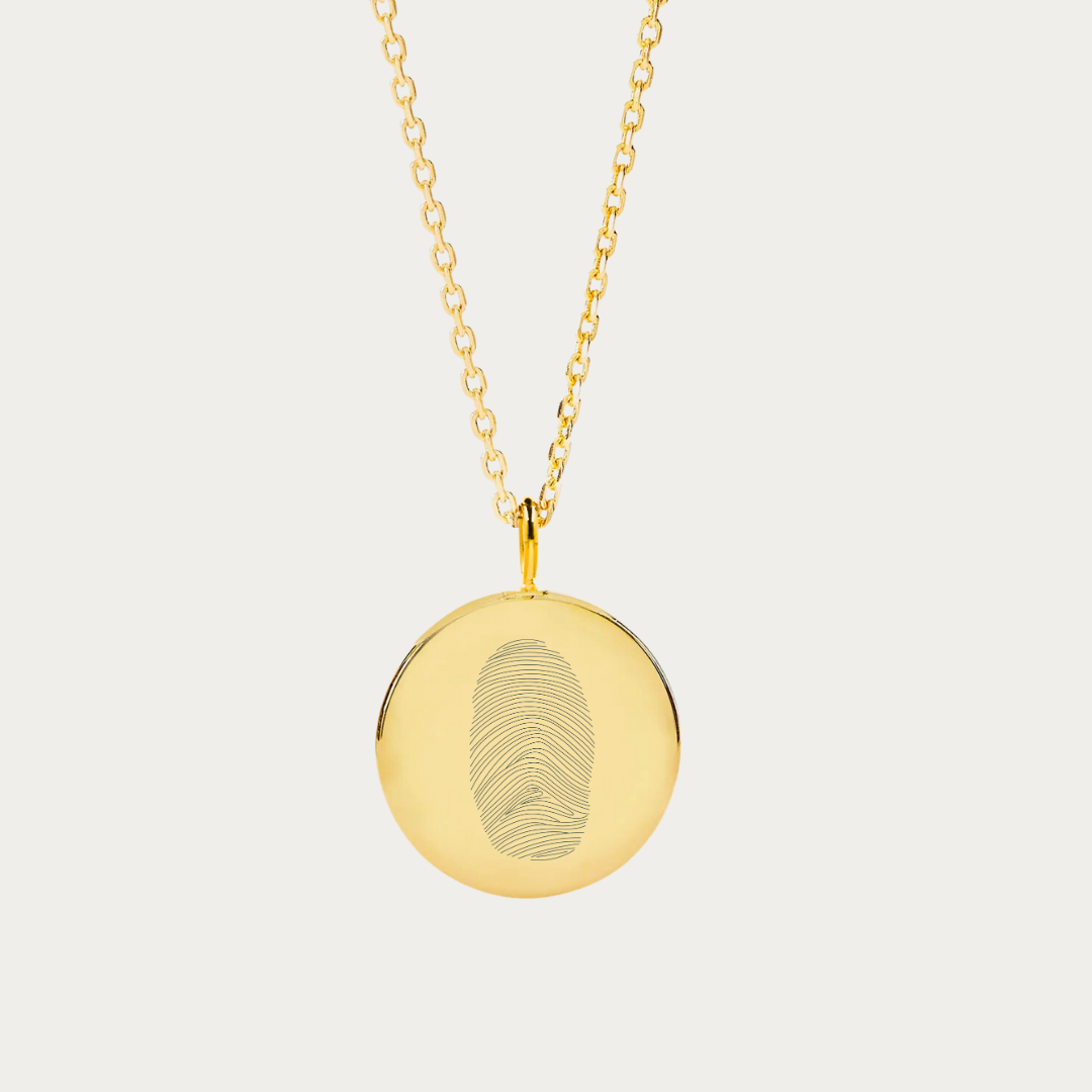 18k gold vermeil necklace elegantly showcases a single fingerprint, engraved onto a coin pendant necklace. As part of the exclusive Danibydsgn fingerprint necklace line, it offers a blend of luxury and individuality, making it an ideal personalized gift. Beyond its charm as an engraved necklace, it also carries the sentimental value of memorial jewelry, capturing a loved one's touch in a timeless piece. This signature piece of engraved jewelry is not just a fashion statement but a cherished keepsake