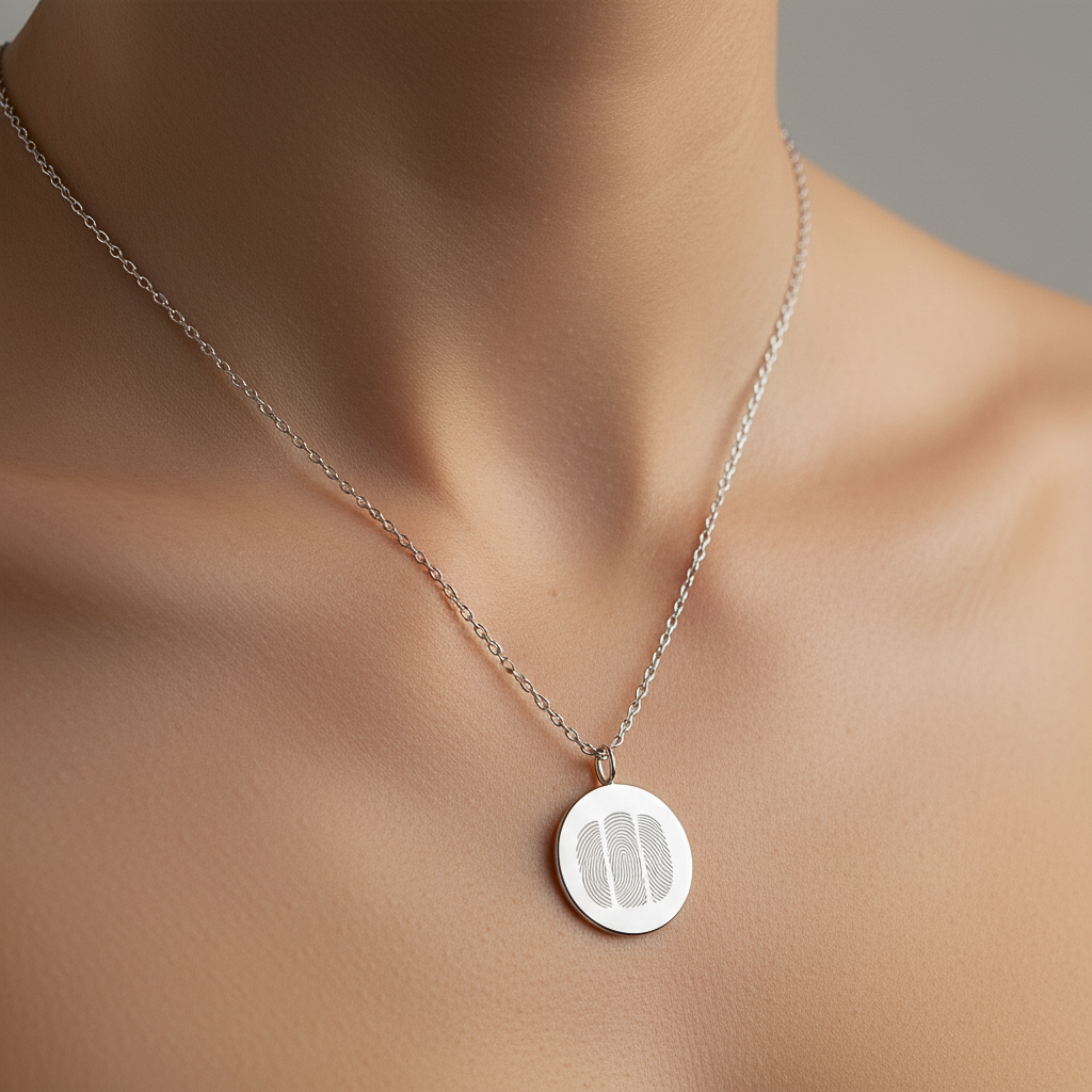 925 sterling silver luxury coin pendant necklace with 3 fingerprints engraved on the pendant and pendant is around the neck of a lady.