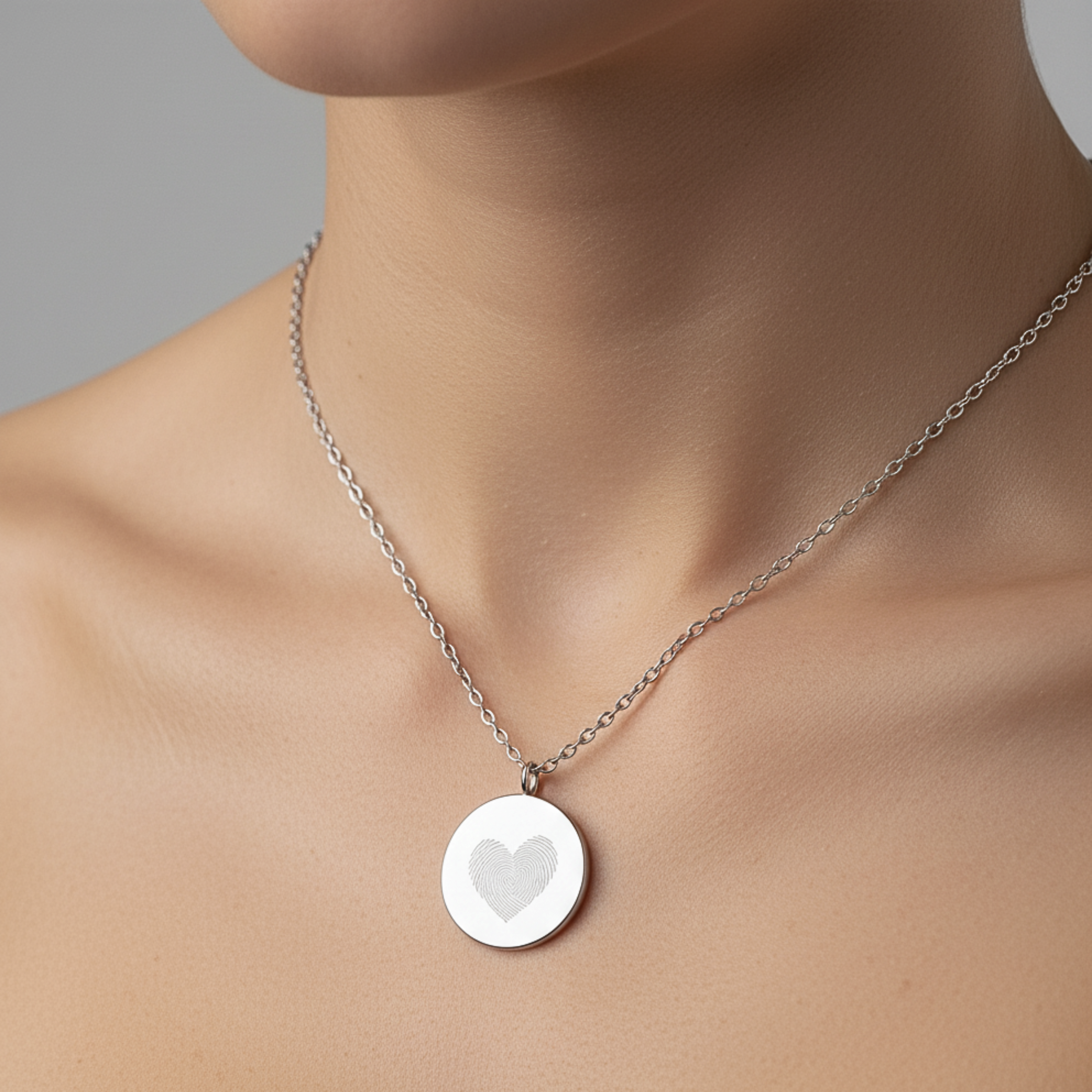 925 sterling silver luxury coin pendant necklace with heart fingerprints engraved on the pendant and pendant is around the neck of a lady.