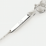 Close-up of the branded clasp and engraved tag in 925 sterling silver, engraved with initials DD, by Danibydsgn.