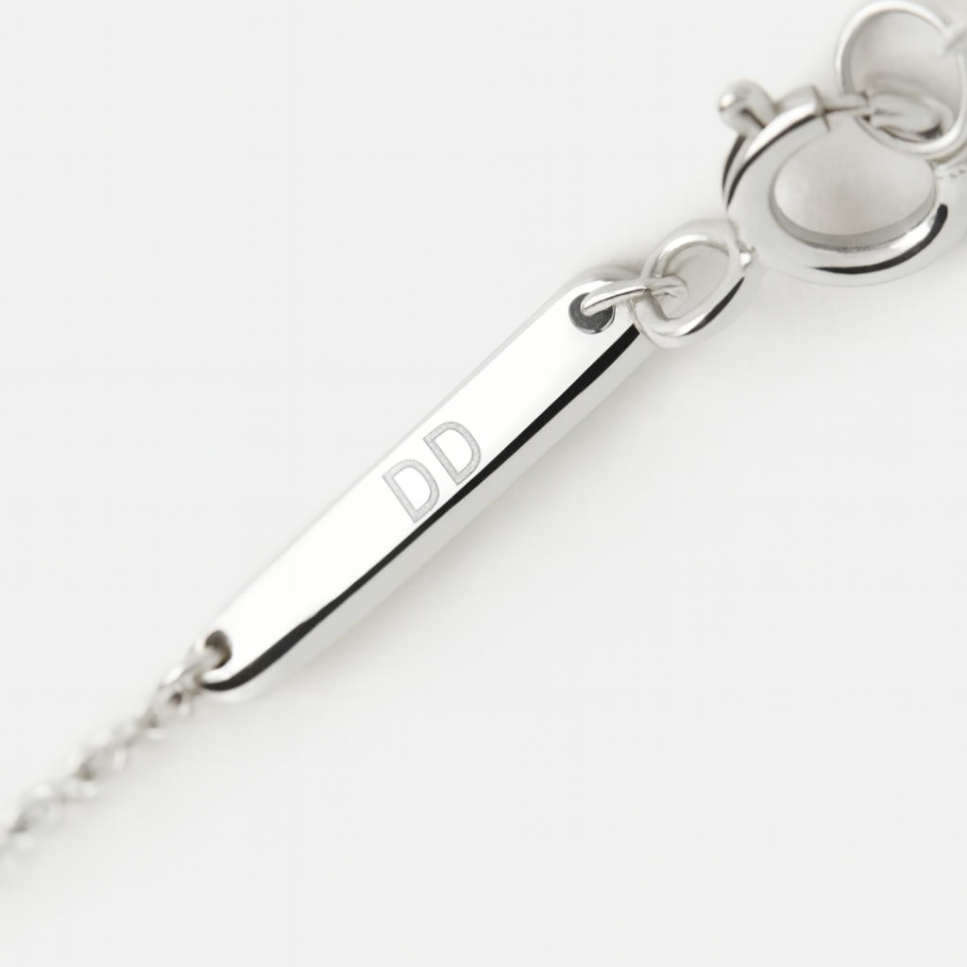 Close-up of the branded clasp and engraved tag in 925 sterling silver, engraved with initials DD, by Danibydsgn.