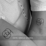 A minimalistic fine line tattoo of an overlapping number Custom Logos design on a couple’s arm of a single symbol date design, exemplifying custom logo design, name tattoo design, and body art. This simple small tattoo idea showcases personal branding and tattoo art, ideal for both name logos and wall art applications.