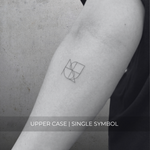 A minimalistic fineline tattoo of an overlapping logo design on a person's forearm of a single symbol design in uppercase letters, exemplifying custom logo design, name tattoo design, and body art. This simple tattoo idea showcases personal branding and tattoo art, ideal for both name logos and wall art applications.