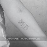 A minimalistic fine line tattoo of an overlapping logo design on a person's inner arm of a two symbol design in uppercase letters, exemplifying custom logo design, name tattoo design, and body art. This simple tattoo idea showcases personal branding and tattoo art, ideal for both name logos and wall art applications.