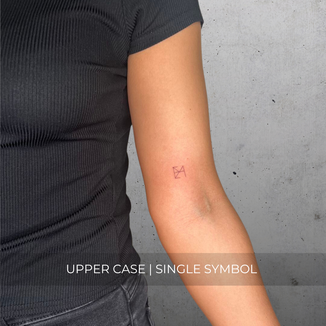 A minimalistic fineline tattoo of an overlapping logo design on a person's inner arm of a single symbol design in uppercase letters, exemplifying custom logo design, name tattoo design, and body art. This simple tattoo idea showcases personal branding and tattoo art, ideal for both name logos and wall art applications.