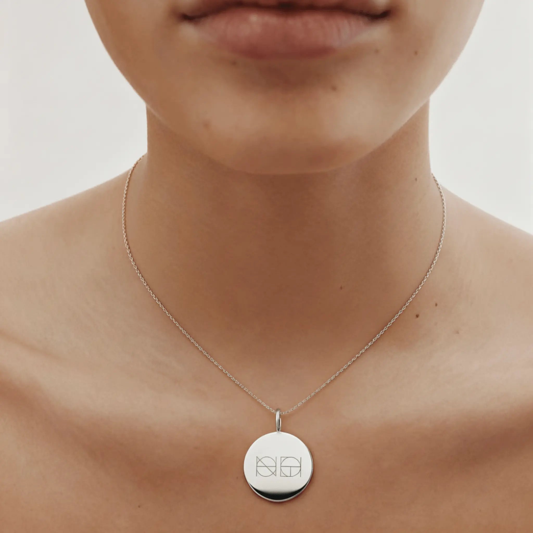 Custom engraved coin necklace in 925 sterling silver by Danibydsgn, showcasing elegant design and fine craftsmanship.