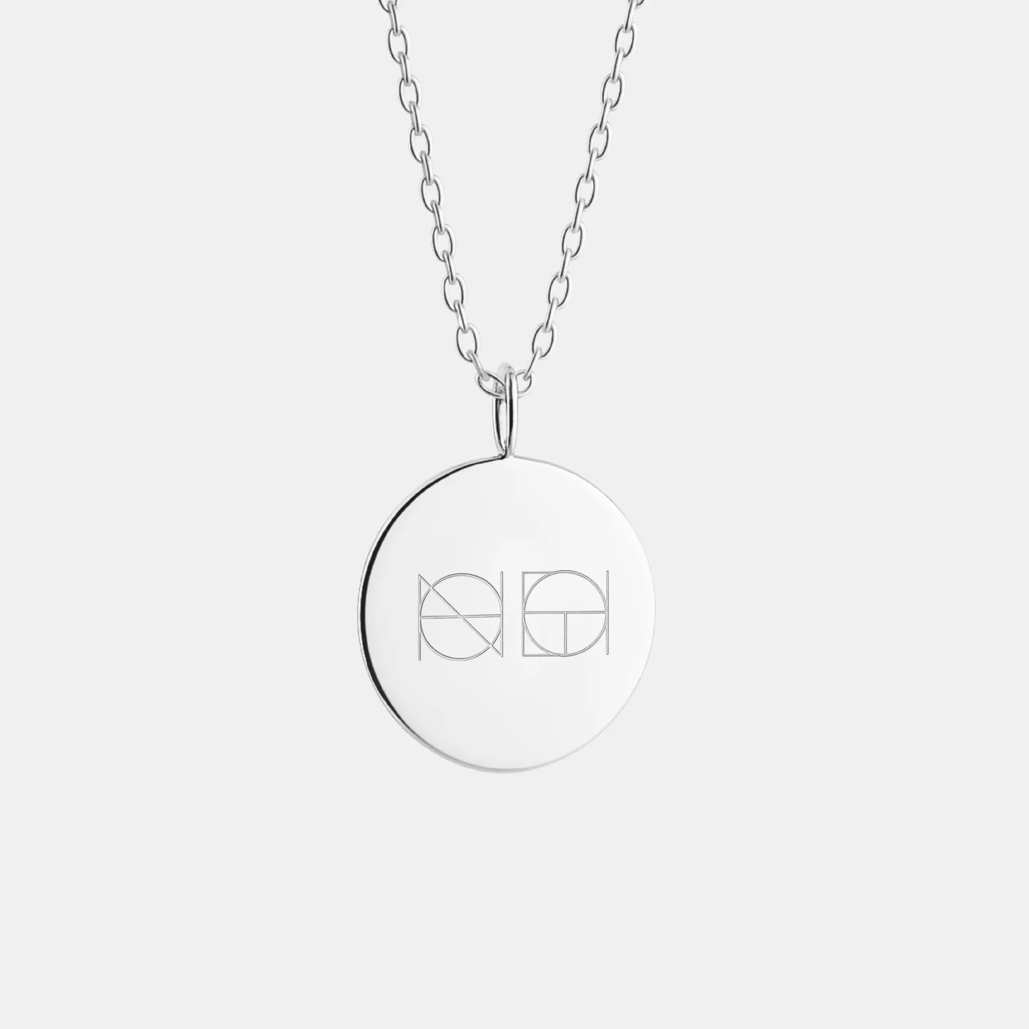 Custom engraved 925 sterling silver coin necklace by Danibydsgn featuring a unique two-symbol design.