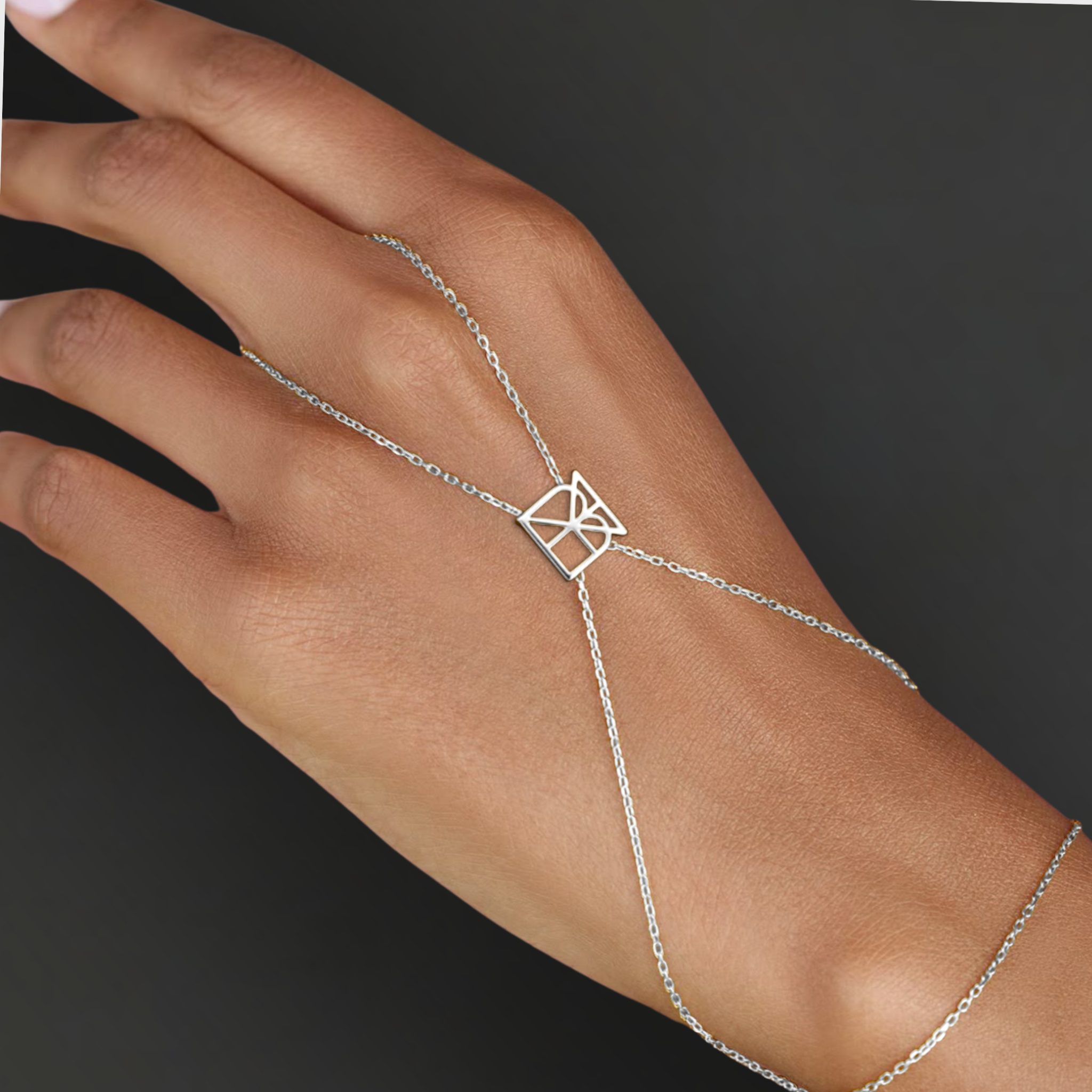 Model wearing Danibydsgn custom symbol hand chain in 925 sterling silver, with a geometric cut-out symbol connector across the back of the hand.