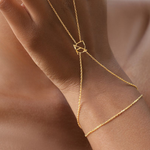 Close-up of Danibydsgn custom symbol hand chain in 9K gold, showing the fine chain and cut-out symbol connector on the wrist.