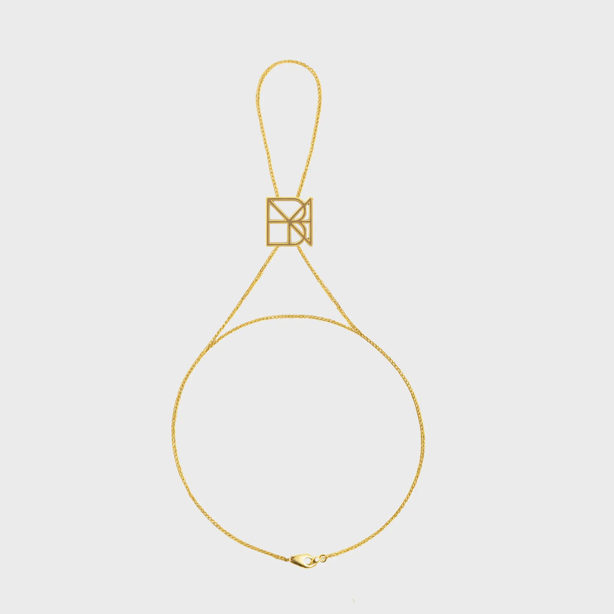 Danibydsgn custom symbol hand chain in 9K gold, featuring a geometric cut-out symbol connector with fine chain and clasp.