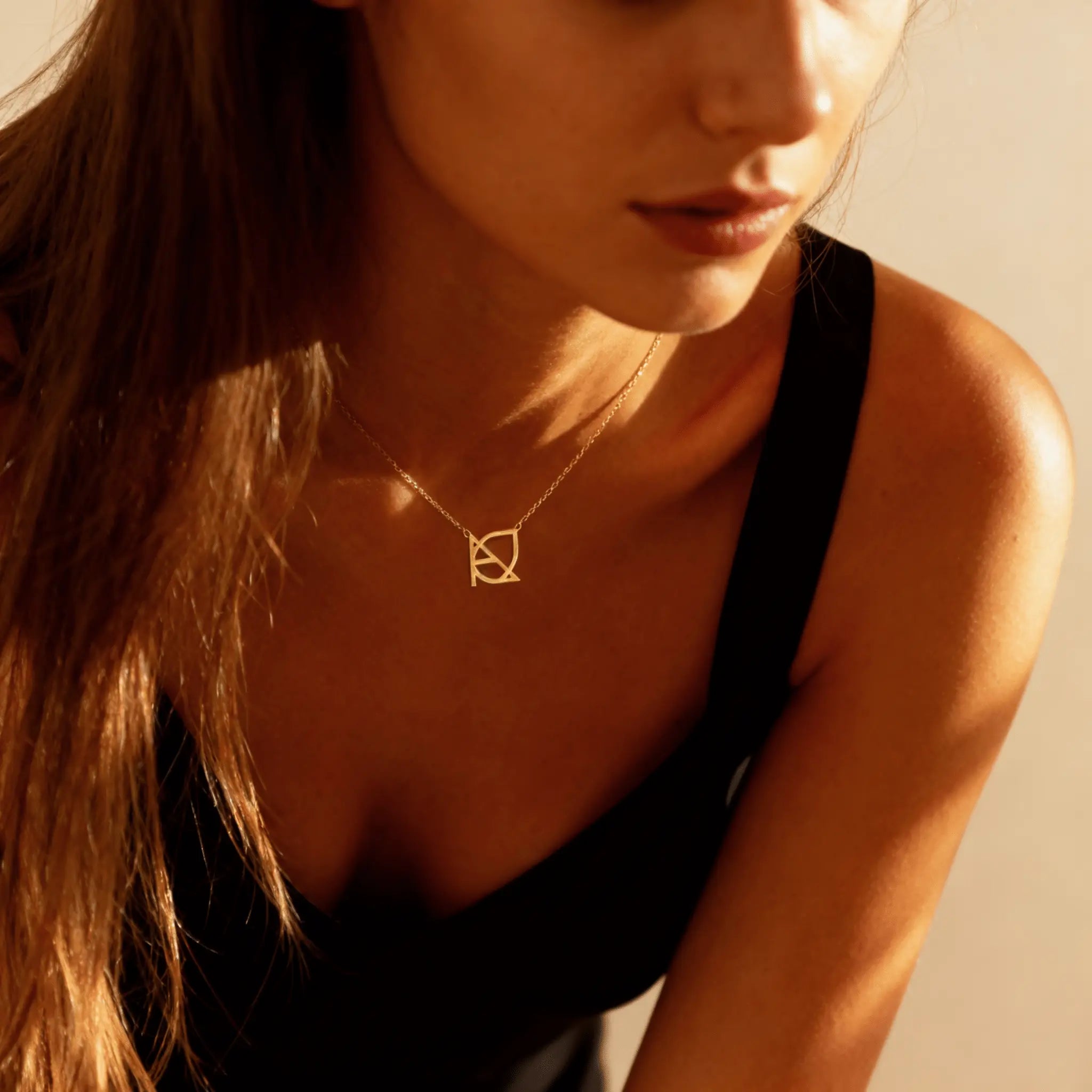 DaniByDsgn custom symbol necklace worn layered on collarbone – personalized 9k yellow gold minimalist pendant, luxury one-of-a-kind initial jewelry