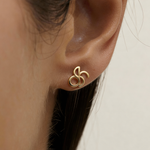 Close-up of Danibydsgn custom symbol stud earring in 9k Gold worn on ear, showing the cut-out silhouette design.