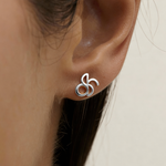 Close-up of Danibydsgn custom symbol stud earring in 925 sterling silver worn on ear, showing the cut-out silhouette design.